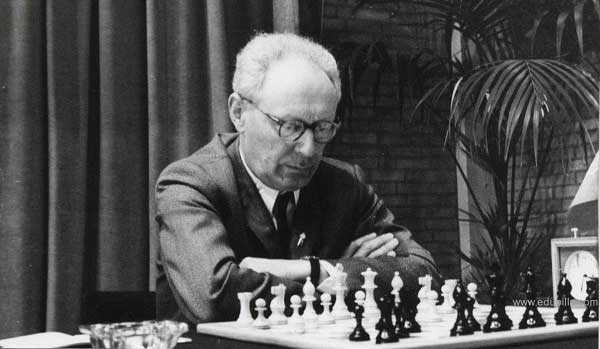 Mijaíl Botvínnik pensando jugando al ajedrez con reloj en un lindo lugar