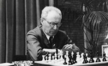 Mijaíl Botvínnik pensando jugando al ajedrez con reloj en un lindo lugar