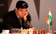 Viswanathan Anand pensando en un tablero de ajedrez tomando un cafe en un taza y con una bandera de india a su izquierda
