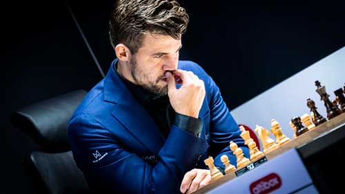 Magnus Carlsen actual campeón del mundo de ajedrez y el mejor jugador de ajedrez de la historia pensando jugando una partida de ajedrez