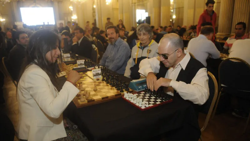 José Luis López reproduce la jugada en su tablero adaptado bajo la mirada de otros competidores y la organizadora Elisa Maggiolo, en el torneo que se disputa en la Legislatura porteña (Foto Dino Calvo)